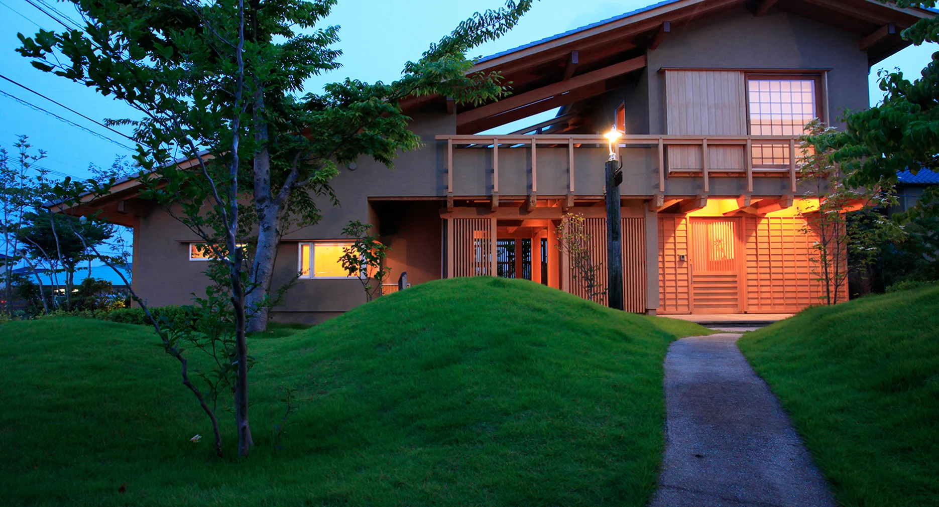 夕暮れに灯りが灯る建築資料館の外観