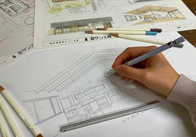 図面に鉛筆でスケッチを描く設計者の手元